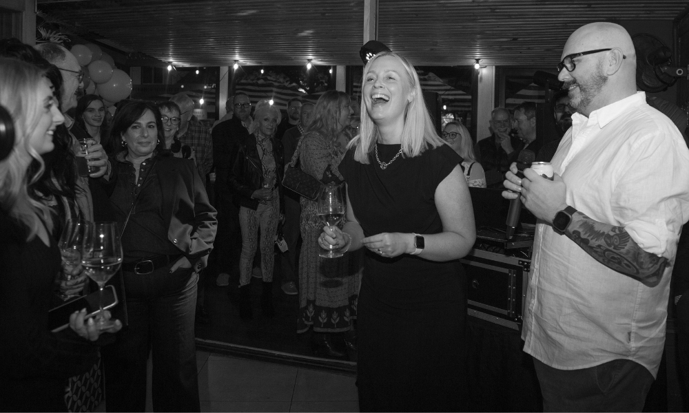 A black & white photo of The Winey Cow's owners at a celebration in their Mornington venue.