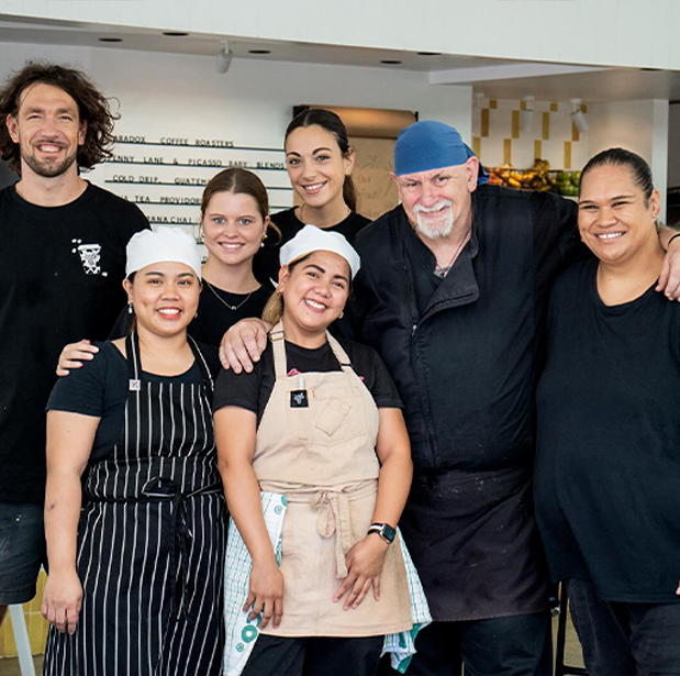 Group photo of The Winey Cow staff, including chefs and waitstaff, smiling together inside the restaurant.