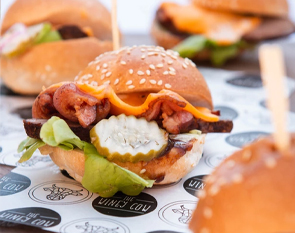 Enjoy our delicious mini bacon cheeseburgers, featuring crispy bacon, melted cheese, pickles, and fresh lettuce, served on a soft sesame bun at The Winey Cow.