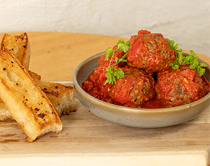 Savoury meatballs in a rich tomato sauce paired with toasted garlic bread, offering a comforting and delicious brunch option at The Winey Cow.