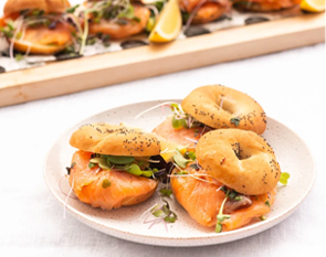 Indulge in The Winey Cow's mini bagels, perfectly paired with smoked salmon and garnished with fresh greens for a delightful catering experience.