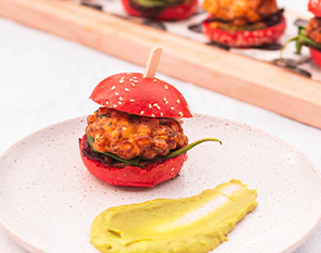 A vibrant mini veggie slider served with a smooth avocado dip, offering a delicious and colorful bite-sized treat at The Winey Cow.