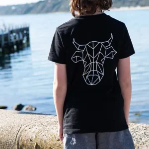 A young boy with his back facing the camera wearing a black t-shirt with The Winey Cow logo in white on the back.