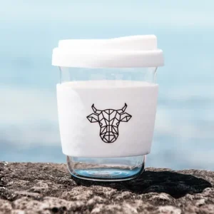 A white keep cup with glass and white silicone band with The Winey Cow logo in black on the front.