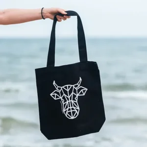 A black tote bag with The Winey Cow logo in white on the front.