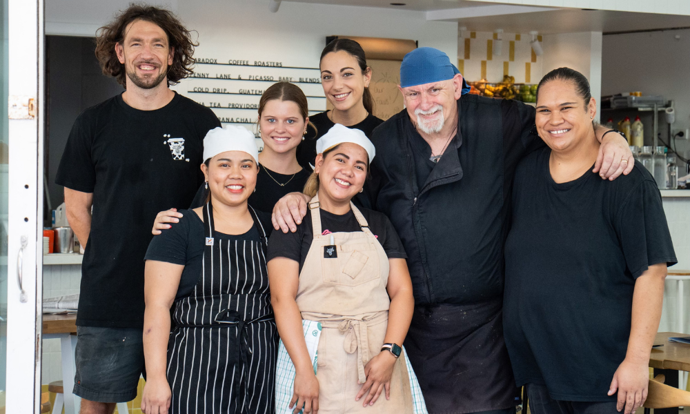 6 staff members at The Winey Cow bunched together smiling at the camera